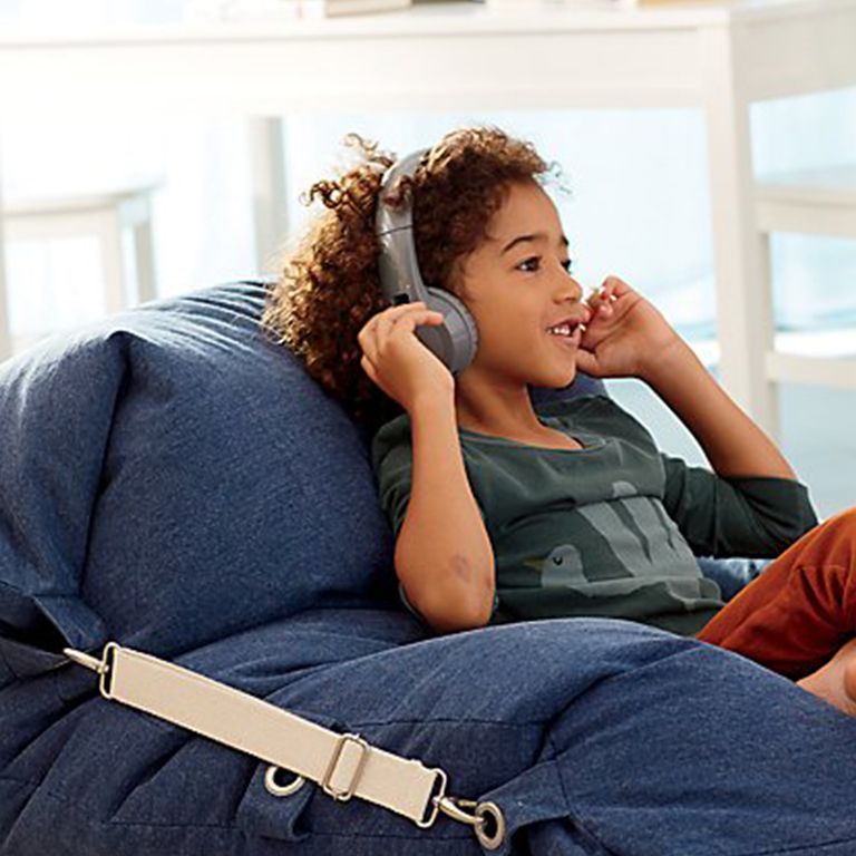 Child with over-ear headphones sitting in Adjustable Blue Beanbag chair