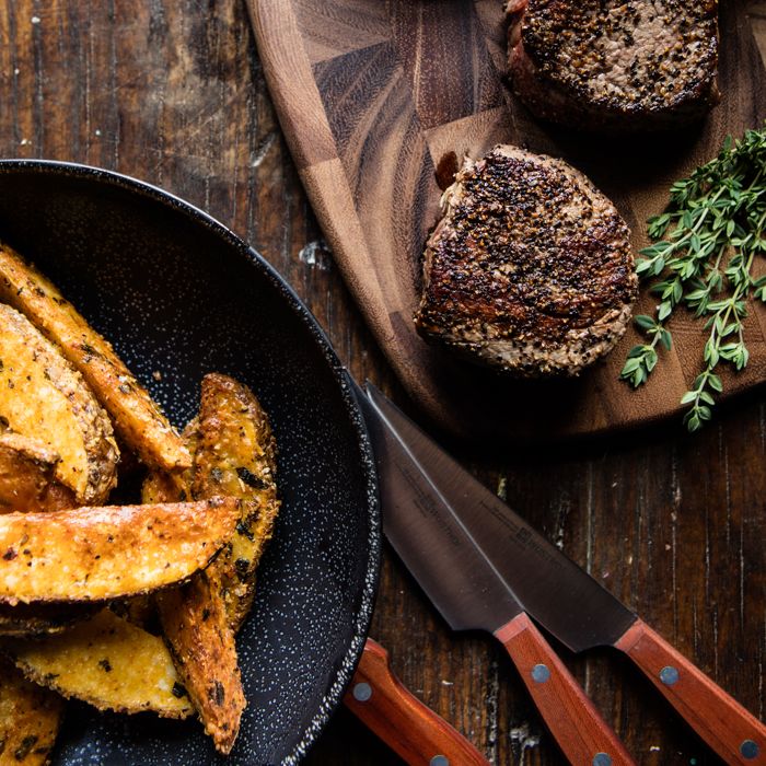 cooked steak next to crispy french fries