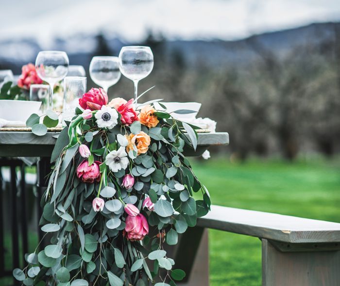 Glassware and flowers set on an outdoor table