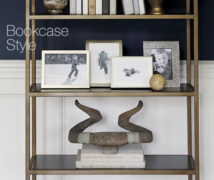 Brass bookshelf with photos, books and decor.