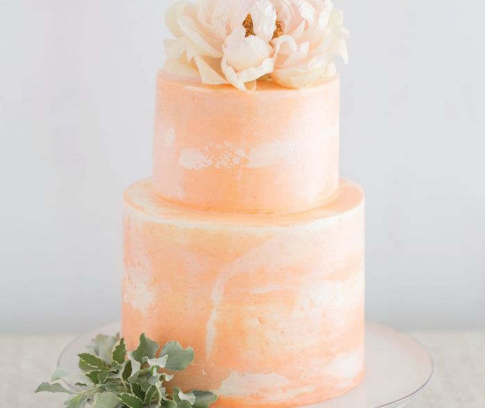 Marble peach color cake with flowers on top.