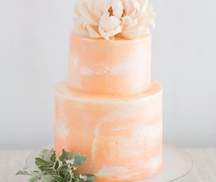 Marble peach color cake with flowers on top.