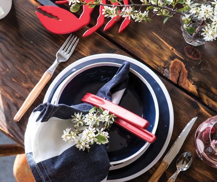Freshly picked flowers added to a napkin holder and set on top of a dinner plate