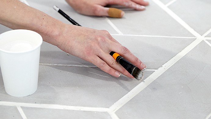 Alexis working on floor tiles.