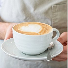 latte in a pure white porcelain cup with subtle concentric circles