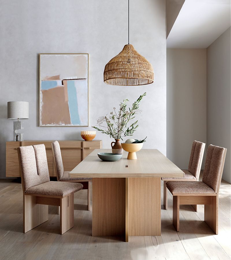 Dining room with natural wood table, four chairs, and rattan ceiling light; organic-looking decor and neutral colors