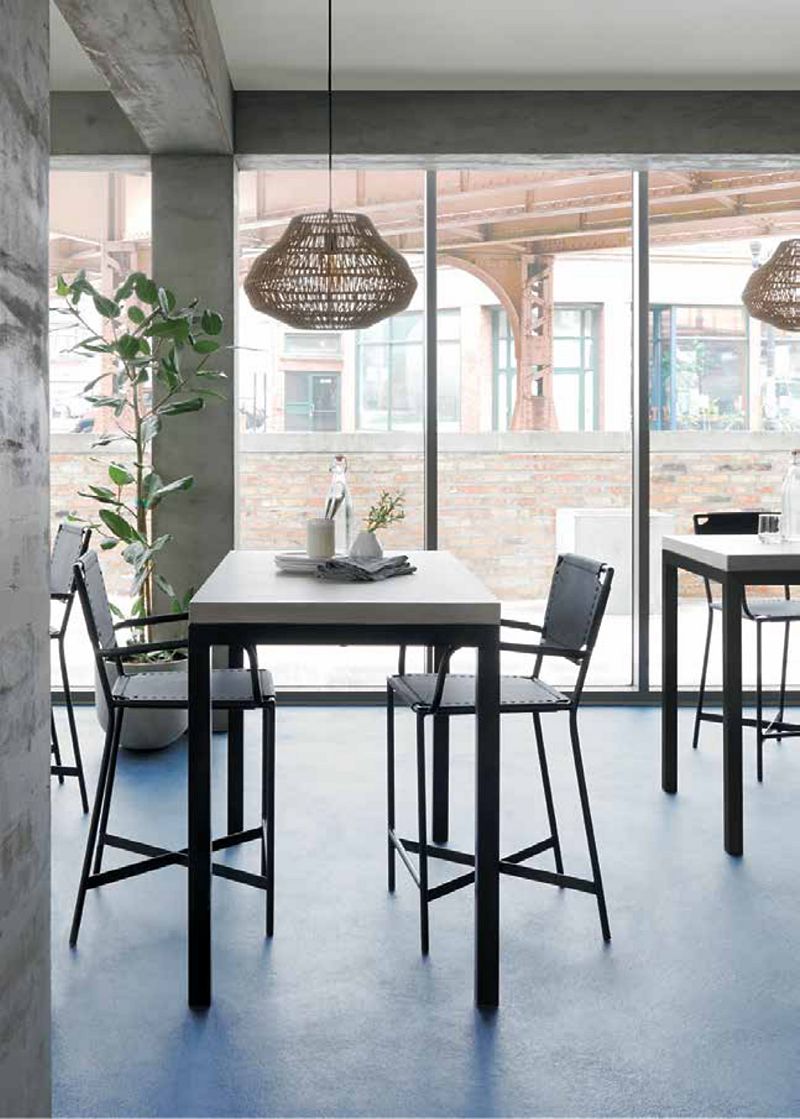 Modern cafe dining space featuring bistro tables and chairs, rattan pendant lights and a view of a bridge through the window