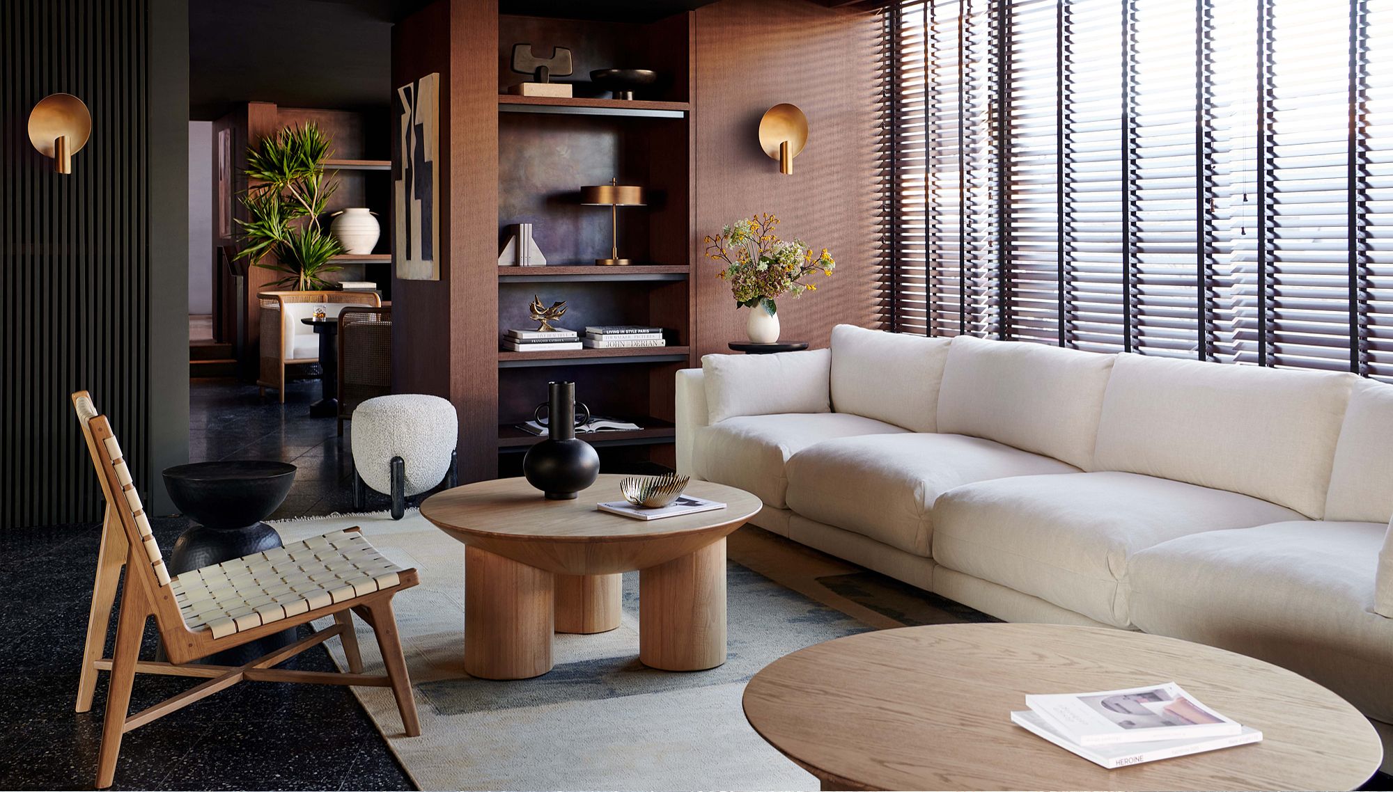 Room with long white couch and two circular wood accent tables