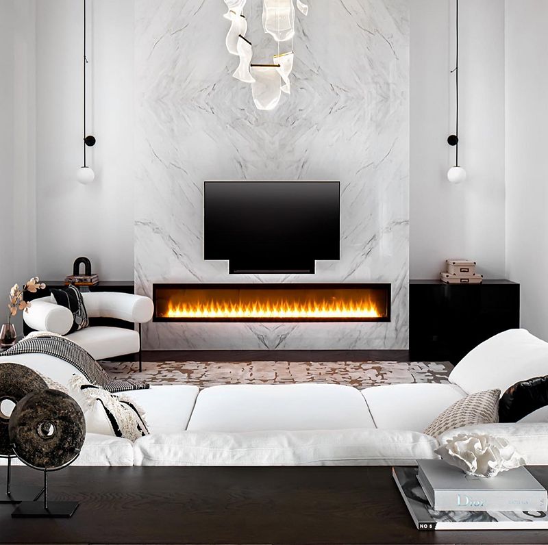 A modern living room with a wall fireplace, in front of which sits a wide white couch and curved white accent chair