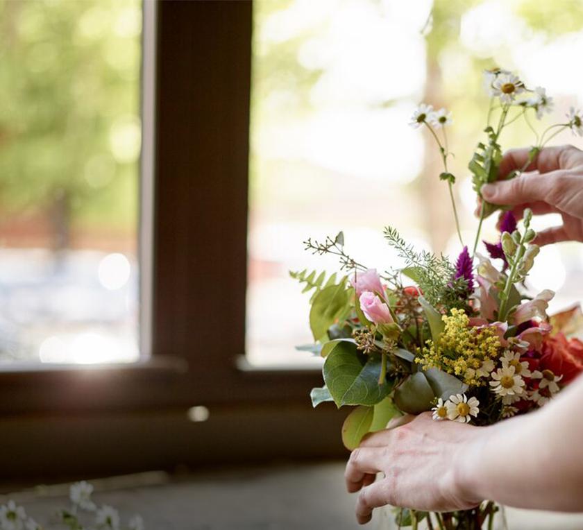 a person adjusting flowers 