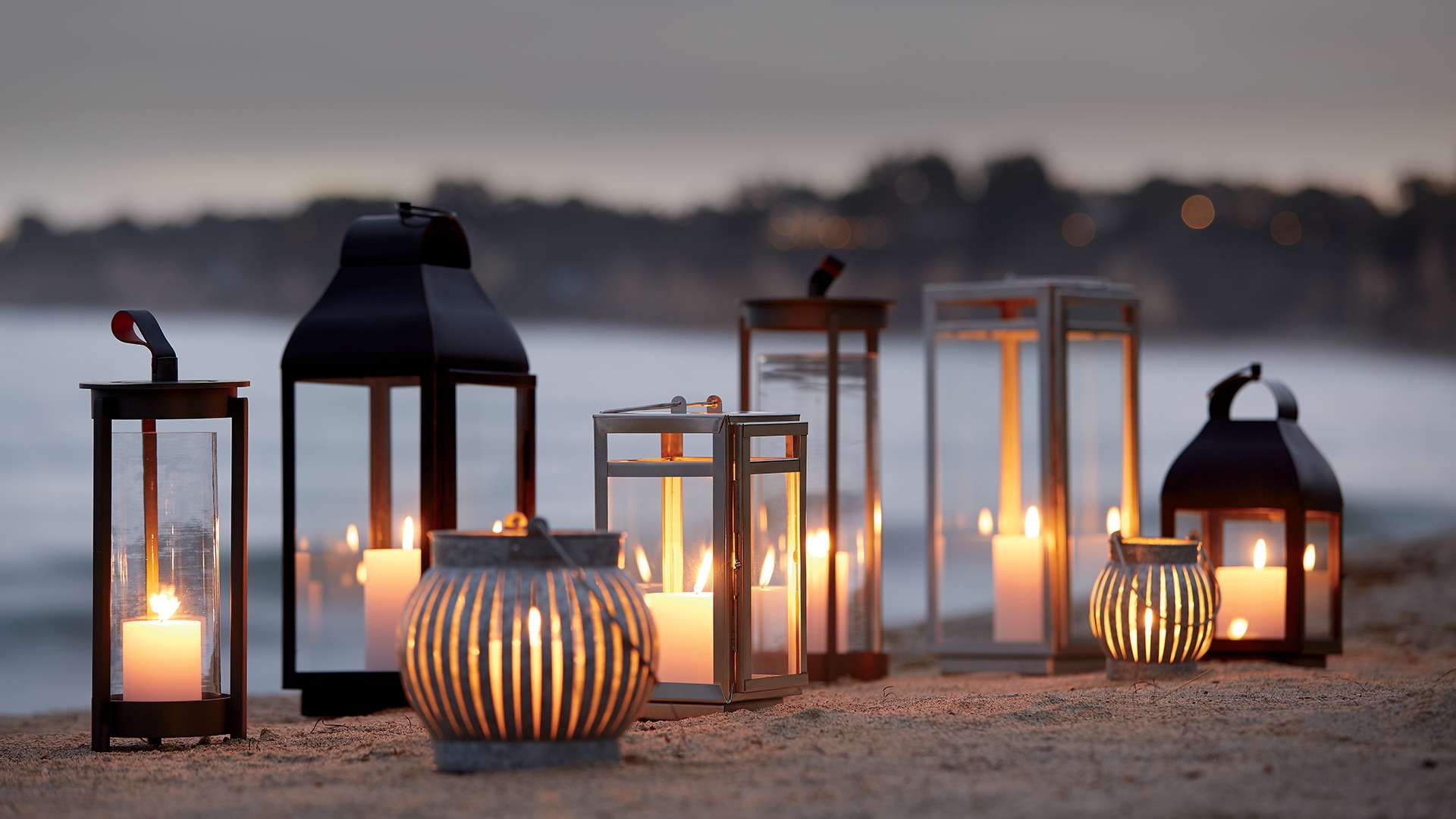 Outdoor Lanterns and Candle Holders lit on a beach