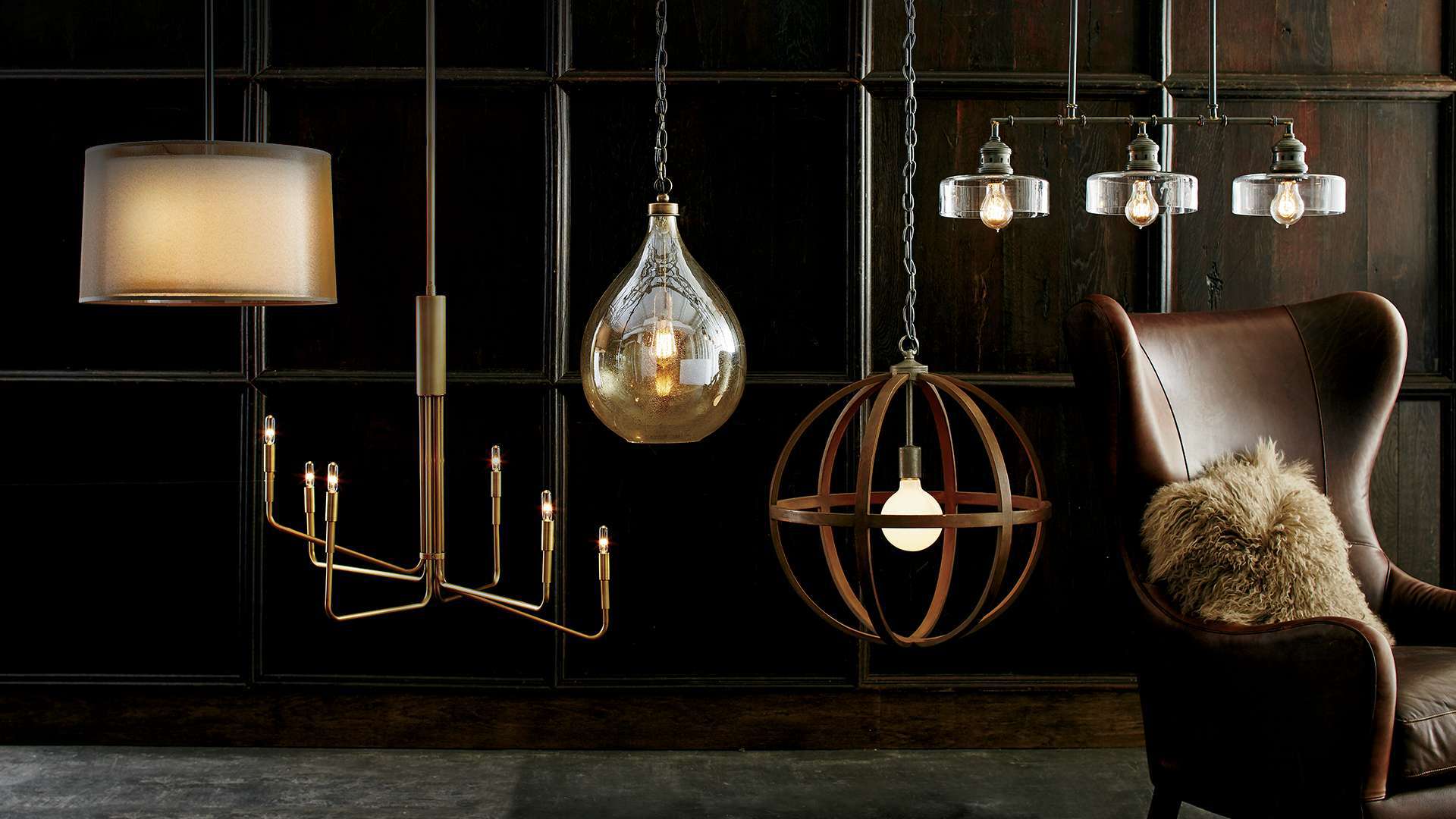 Multiple pendant lights hanging in a room with a leather chair