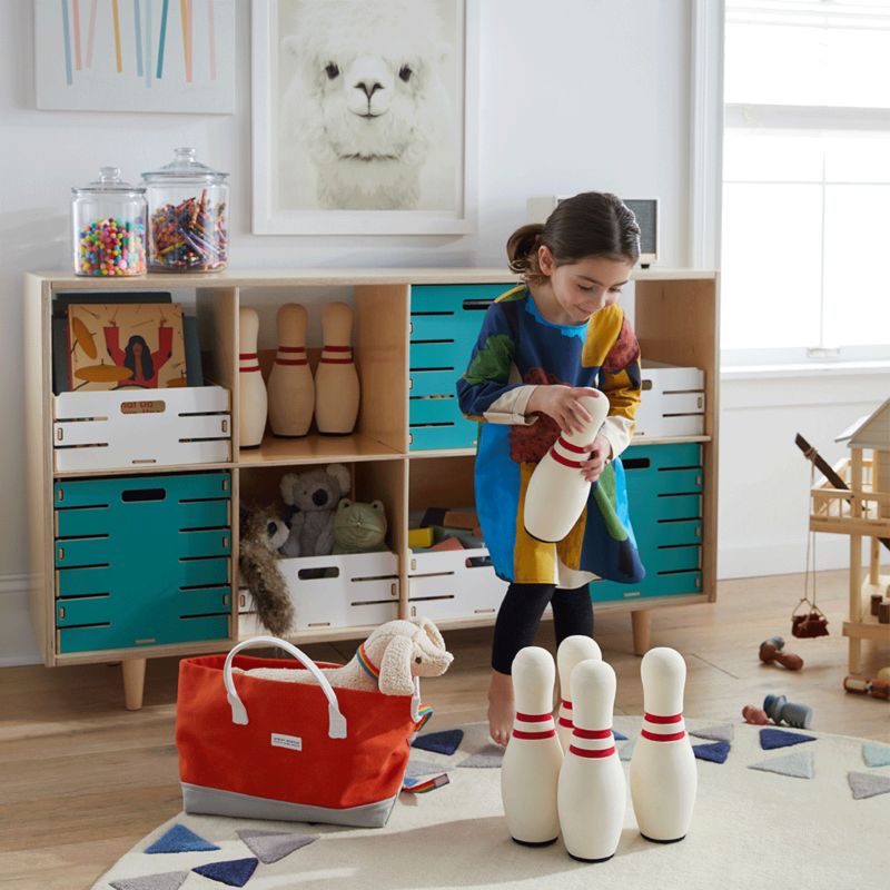 Girl setting up bowling pins in play room