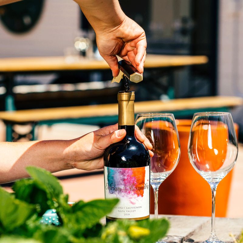 Pair of hands opening wine bottle