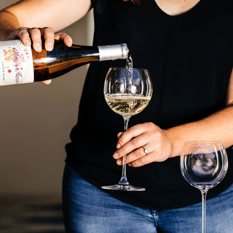 Woman pouring white wine into glass