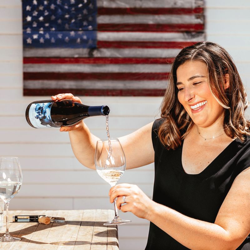 woman pouring white wine into glass