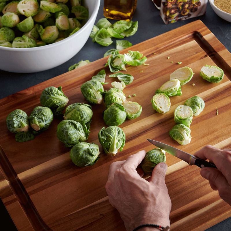 Hands cutting brussels sprouts with pairing knife