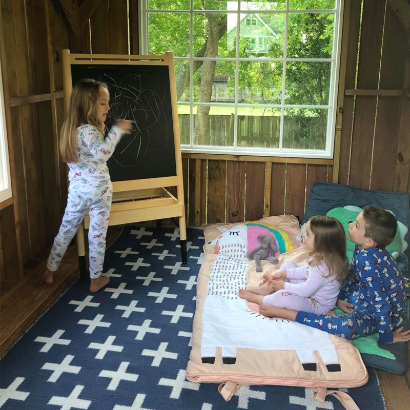 Girl instructing siblings using chalkboard