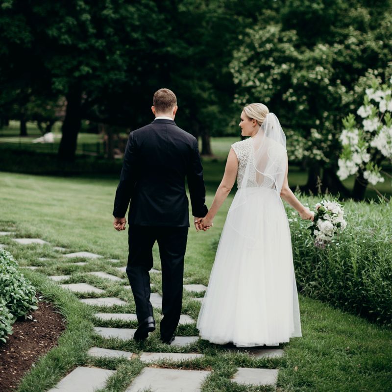 Just married couple walking on stone path in backyard