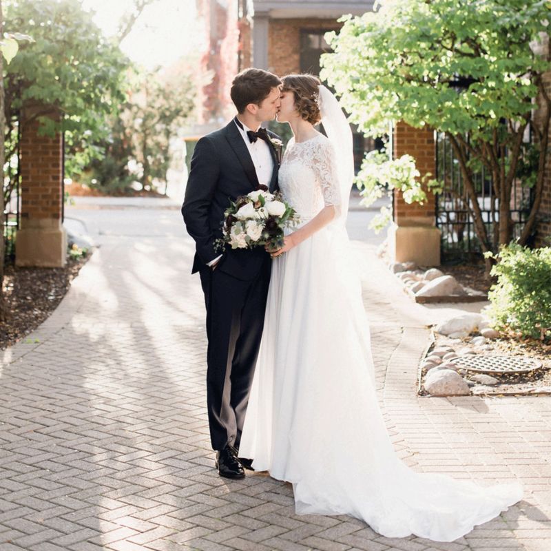 Couple kissing in the middle of a sidewalk