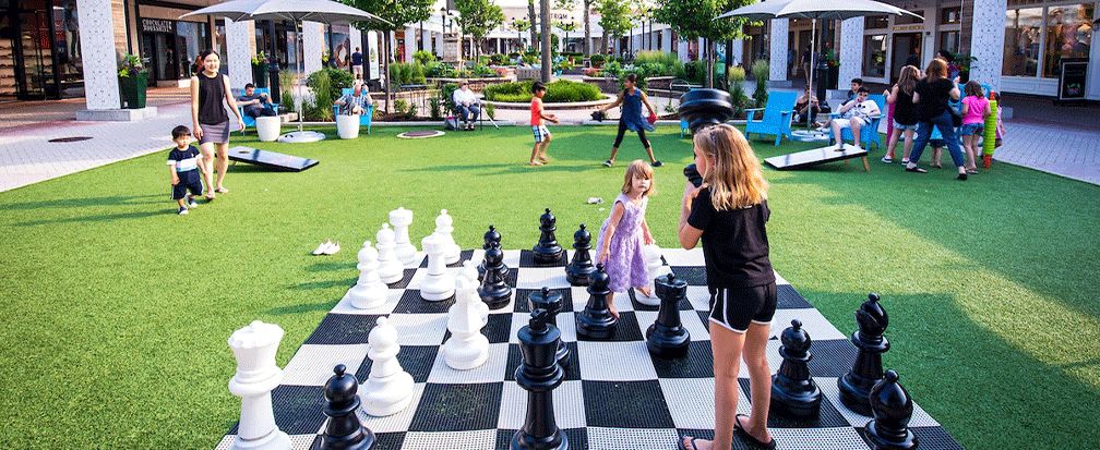 Kids playing with giant chess set outdoors at Old Orchard Mall