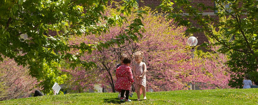 Three children standing in a circle in a park