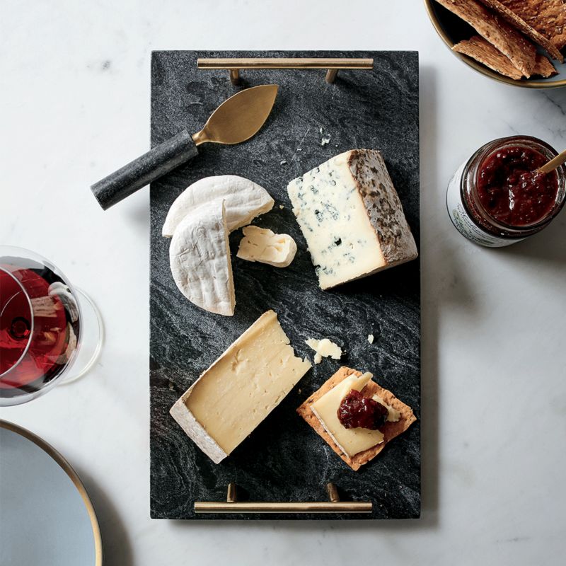 Dark marble charcuterie board featuring multiple types cheese