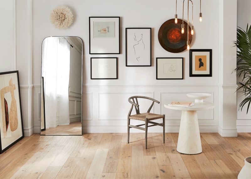 Room decorated with floor mirror and wall art