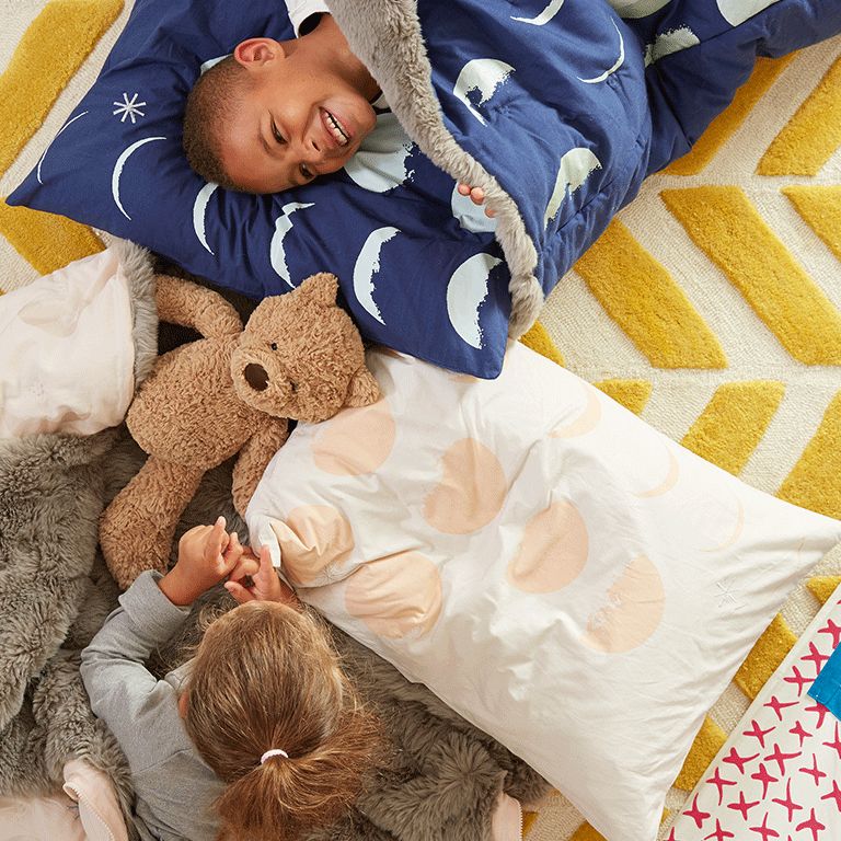 Two children in sleeping bags laughing 