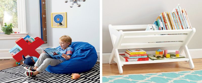 Little boy reading a book in a beanbag chair, white wood bookcase