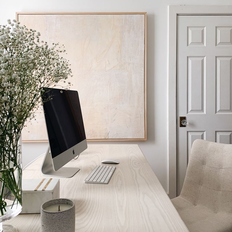 Computer on desk with floral arrangement and candle