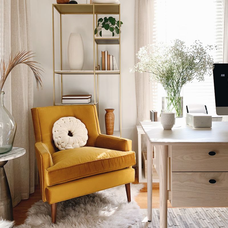 Accent chair positioned in front of bookcase in corner of office