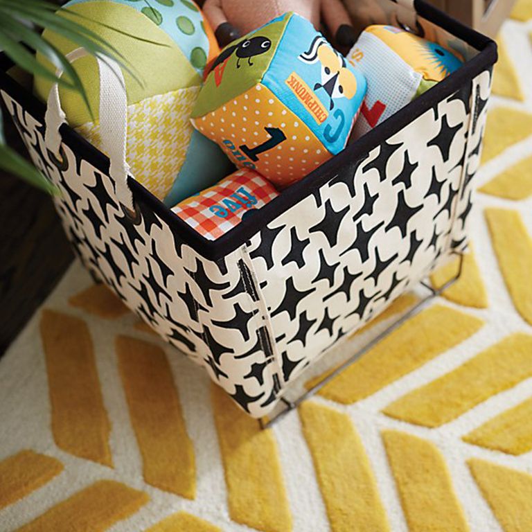 Colorful soft baby toys in a patterned canvas bin